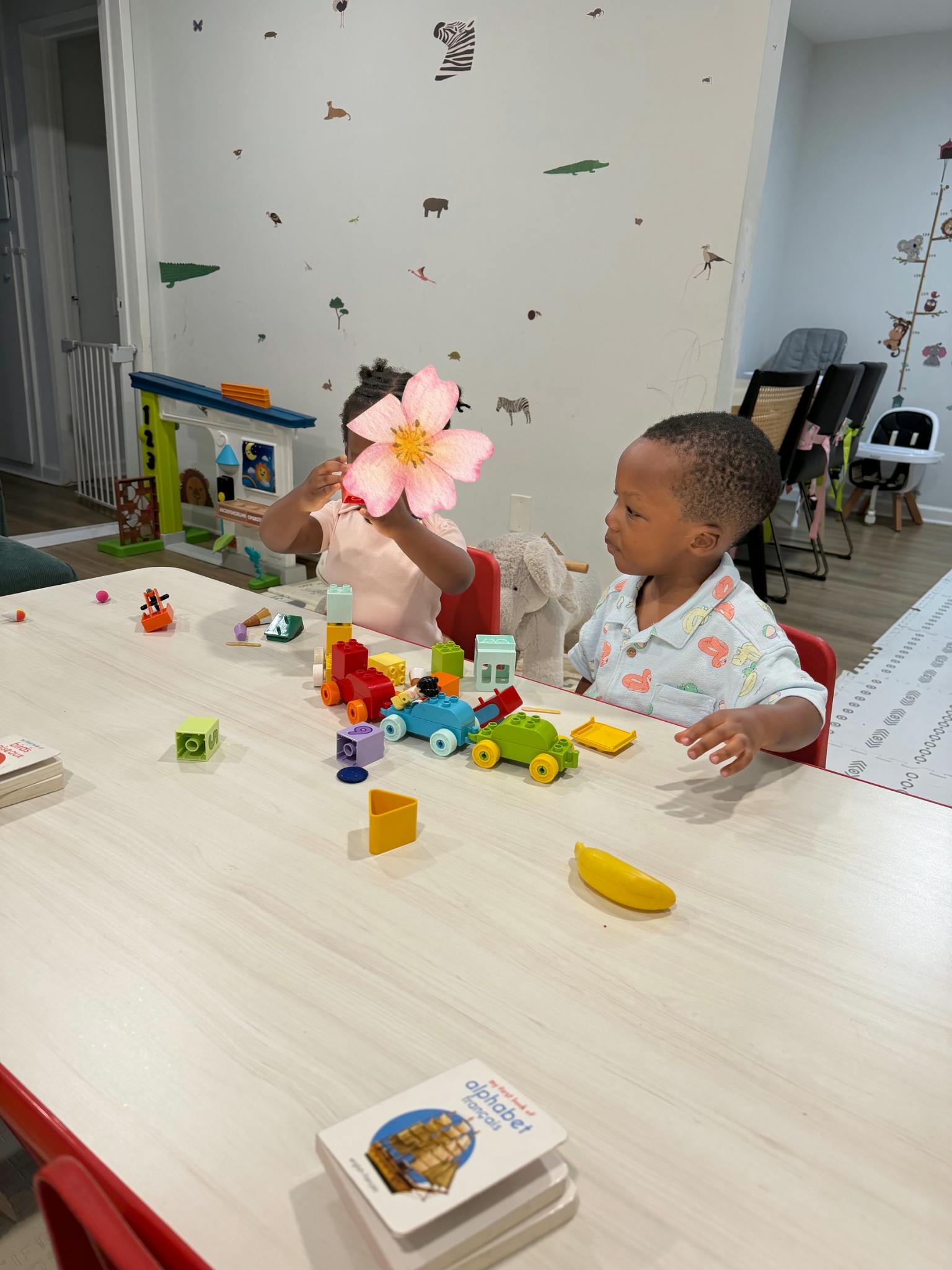 Two children playing with building blocks at a table
