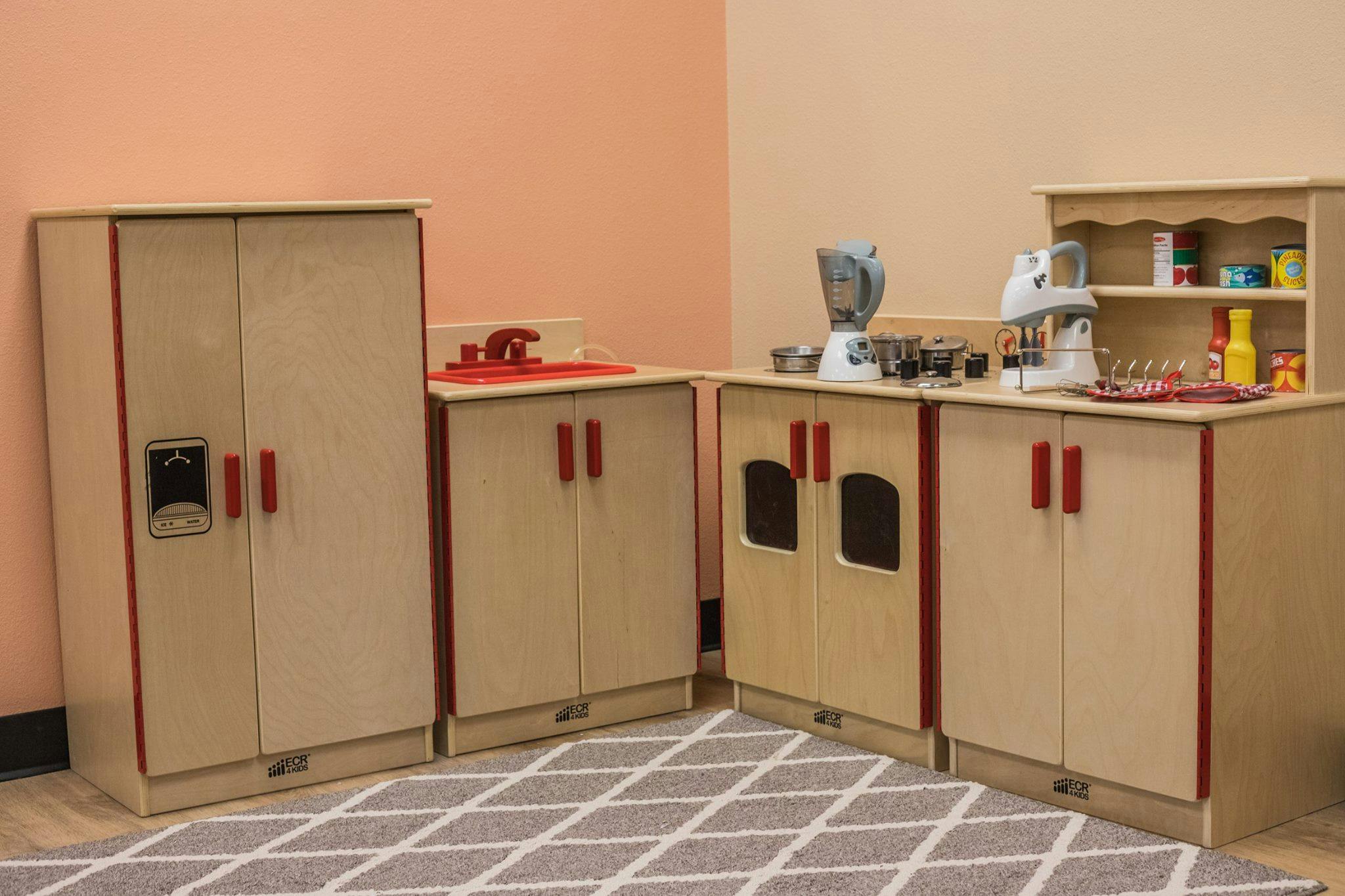 Play kitchen set with refrigerator, sink, and stove