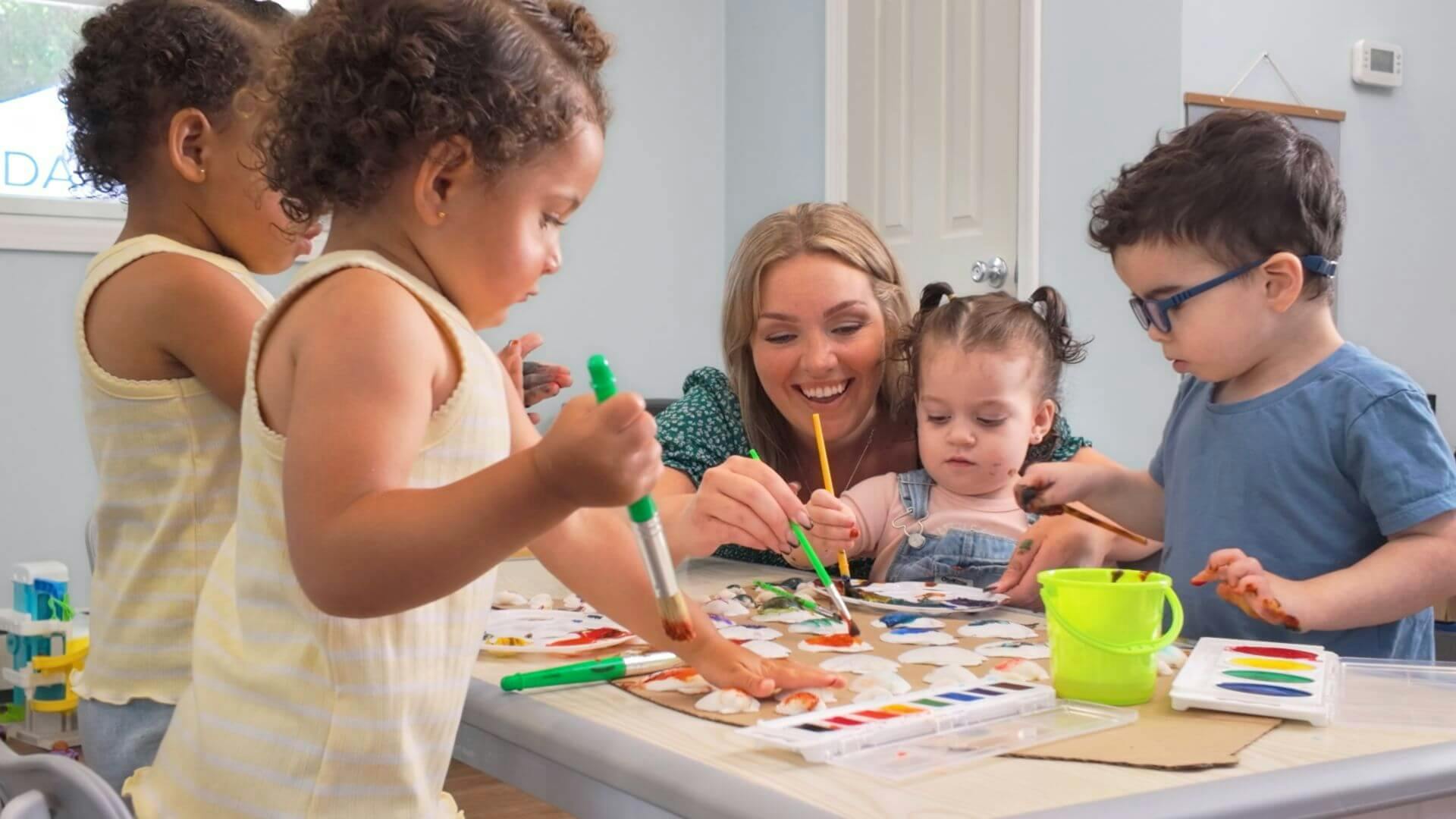 Adult and children painting on paper at a table