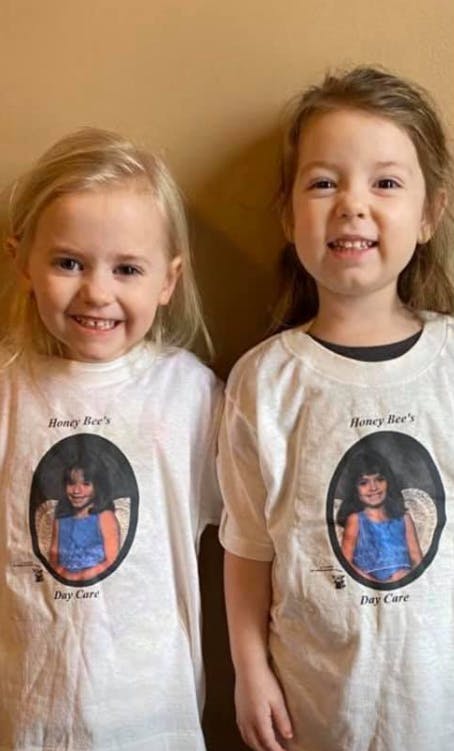 Two children wearing white t-shirts with a photo of a child on each