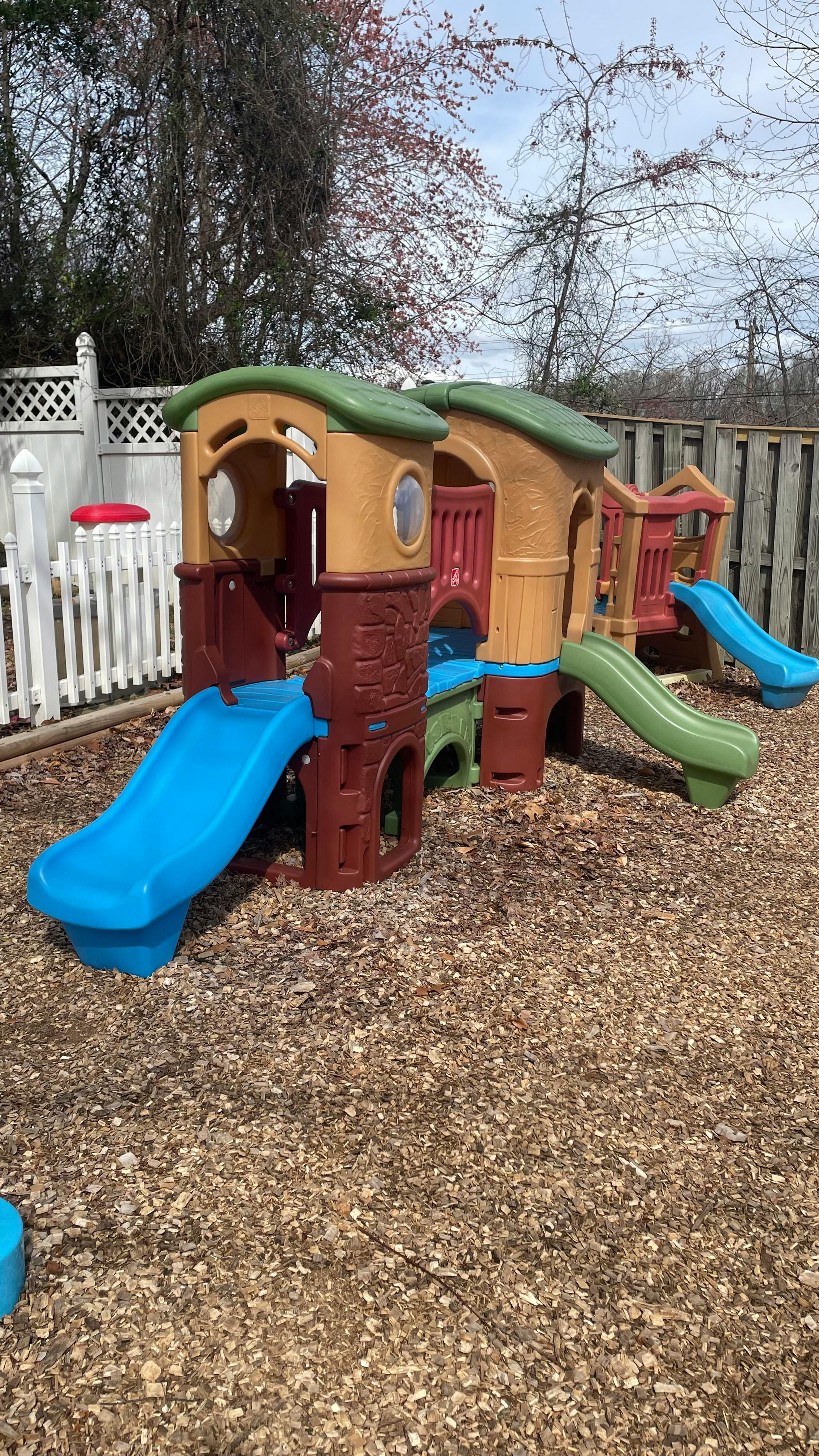 Playground structure with multiple slides on wood chips