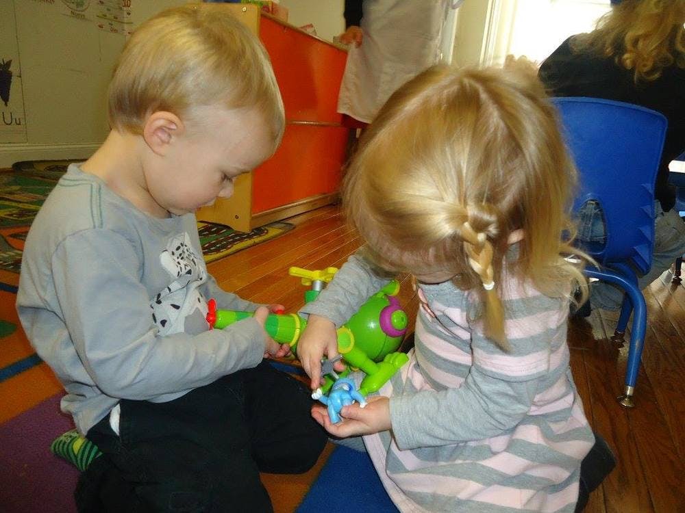 Two children playing with toys on the floor