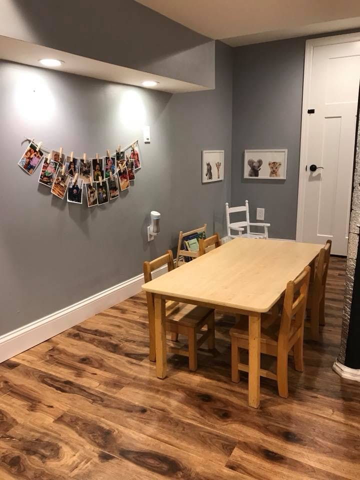 Children's table and chairs in a room with photos strung on a wall