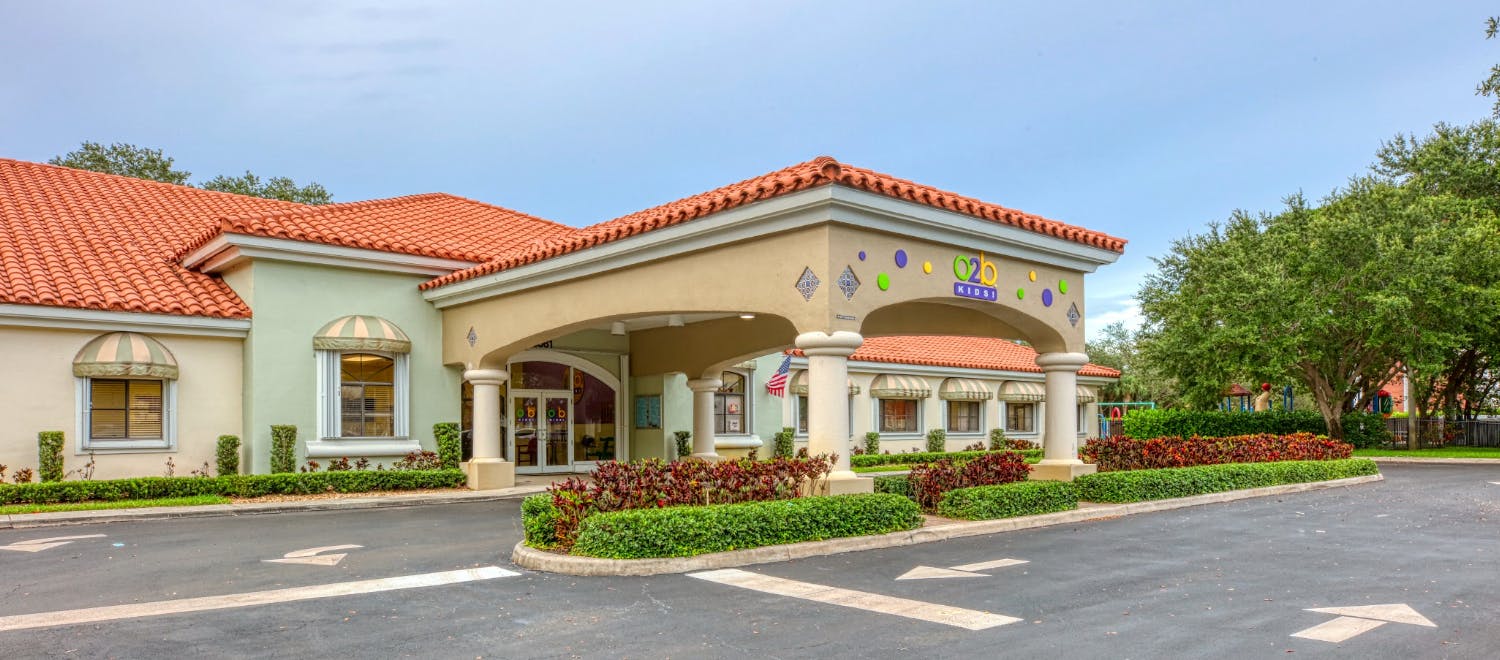 Exterior of a building with a red tile roof and a covered entryway