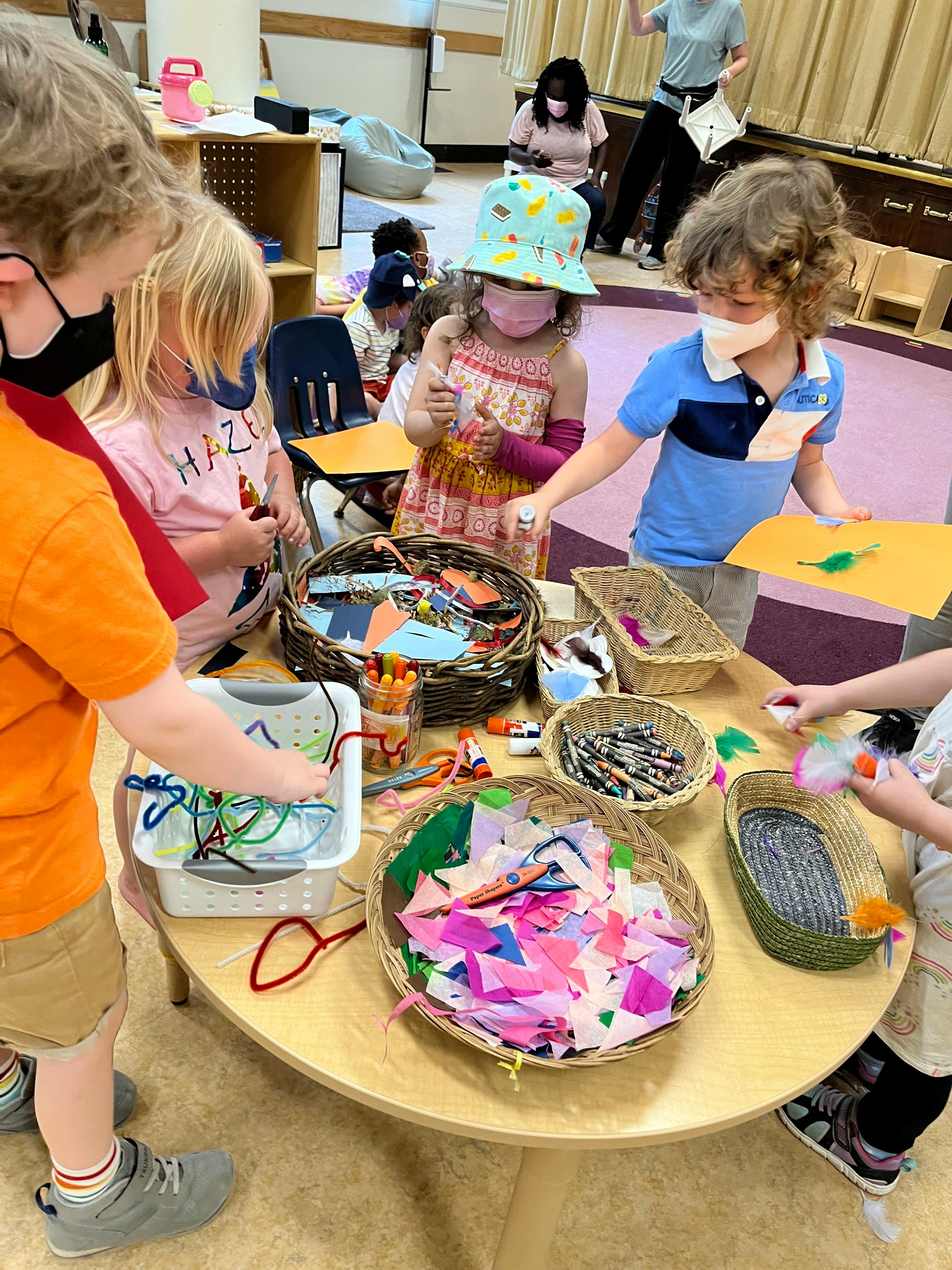 Children gathered around a table with craft supplies