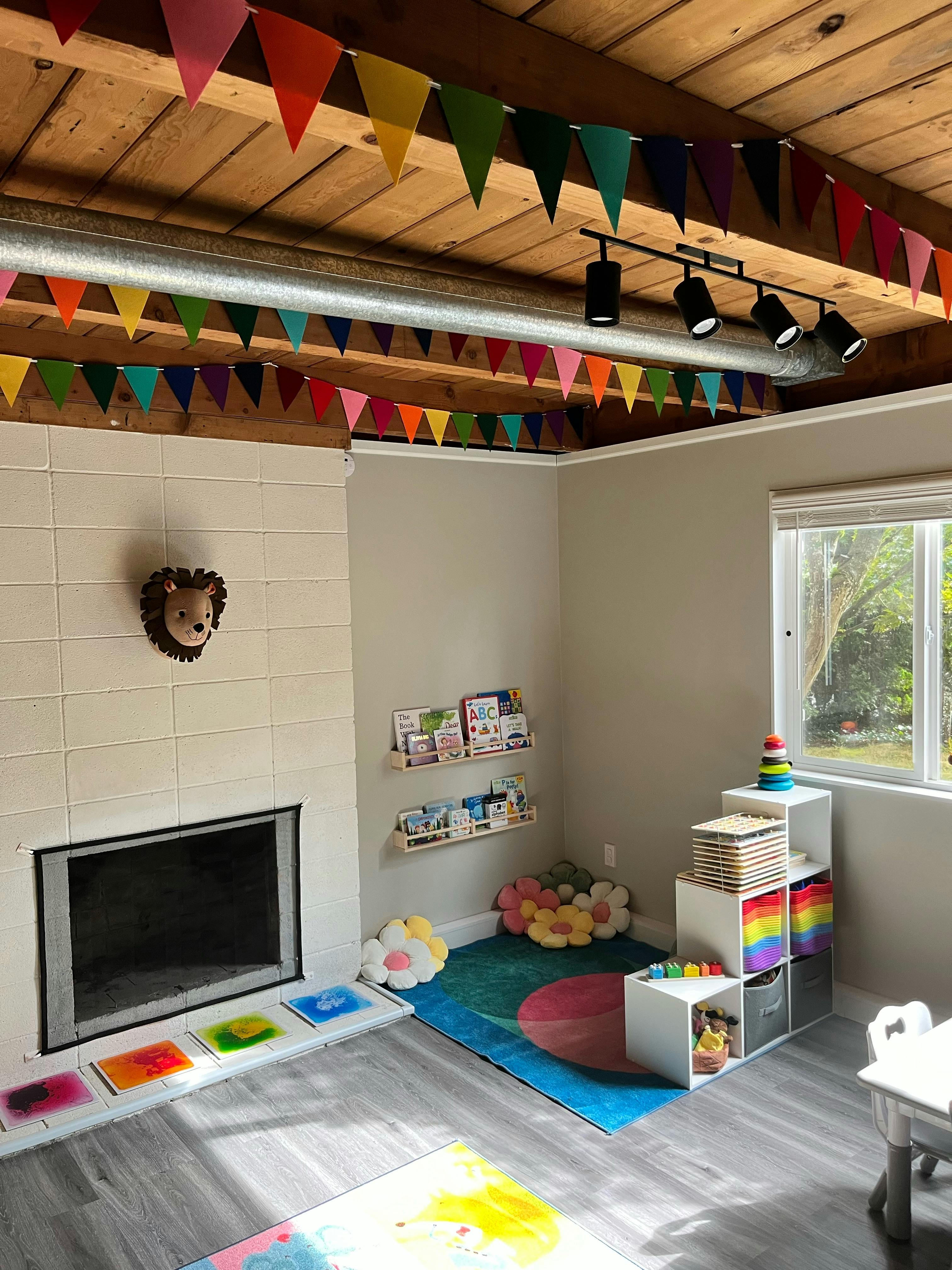 Playroom with colorful decorations, fireplace, and toys