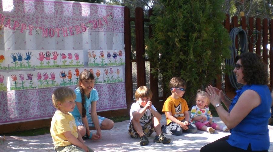 Adult and four children sitting on the ground