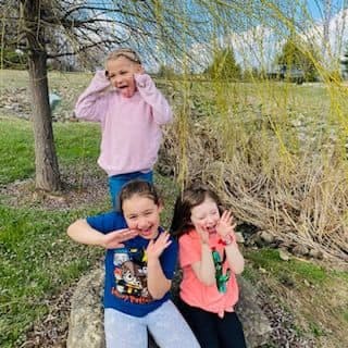 Three children making funny faces outdoors