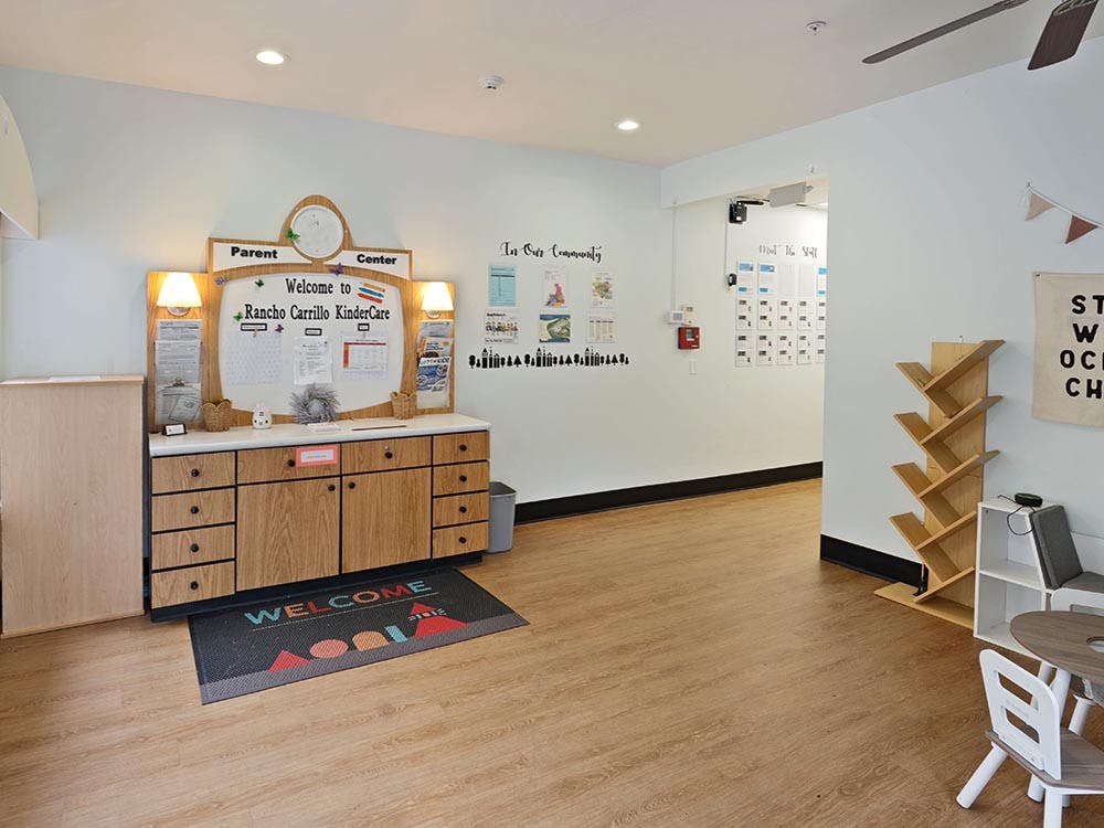lobby of a childcare center with a welcome desk and bulletin board
