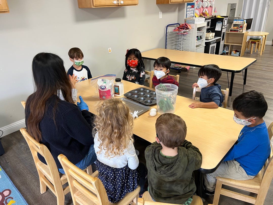 Adult and children sitting around a table in a classroom