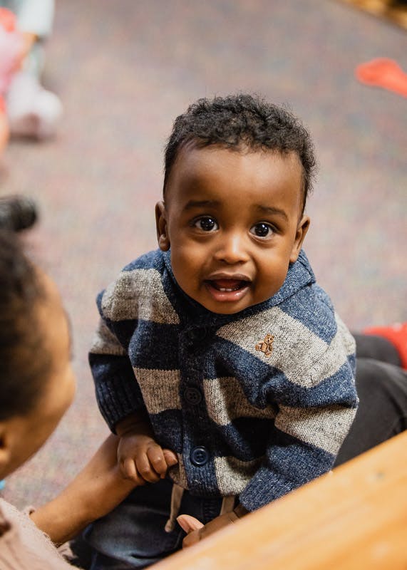 Child in a striped sweater looking up