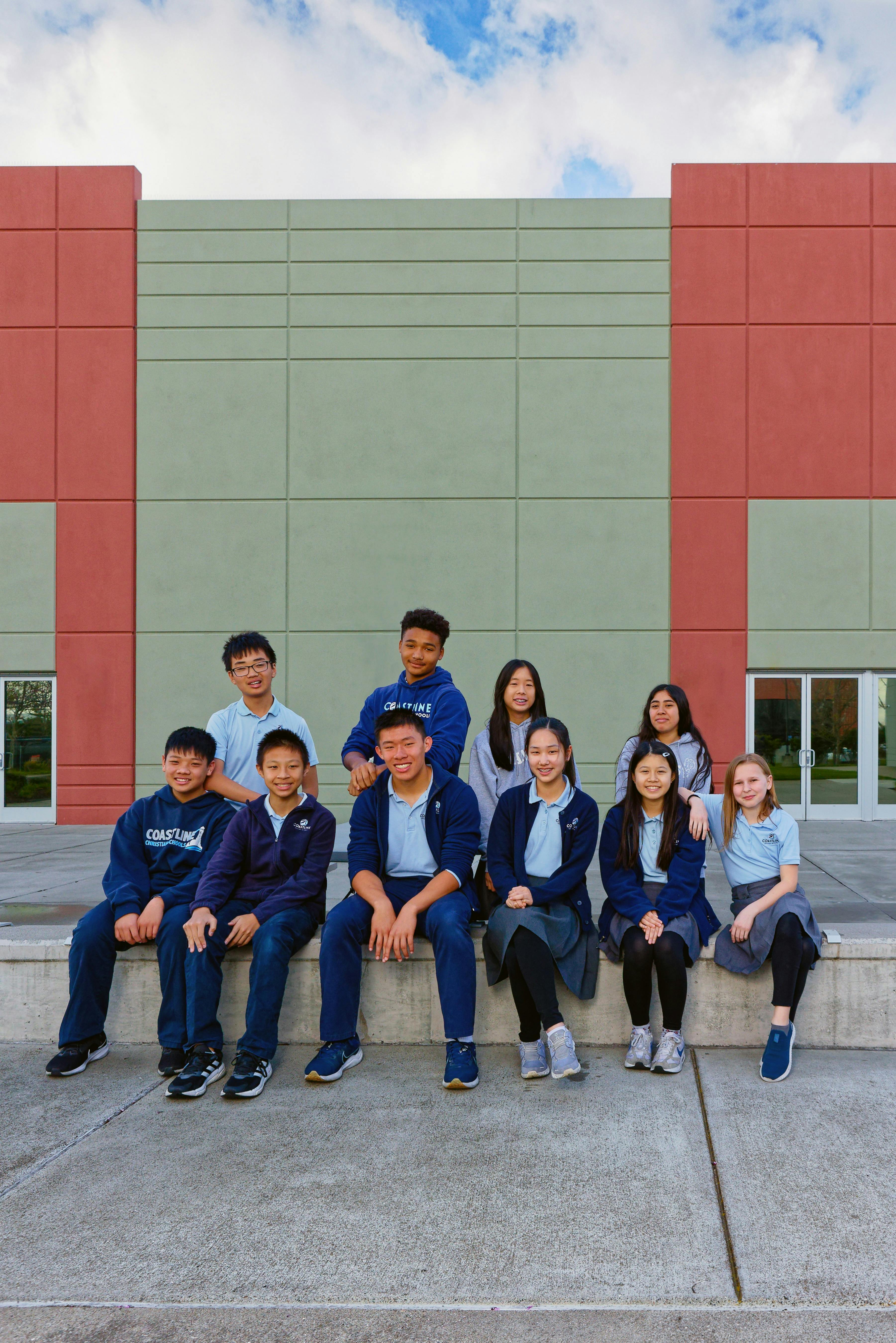 Group of teens and children sitting outdoors