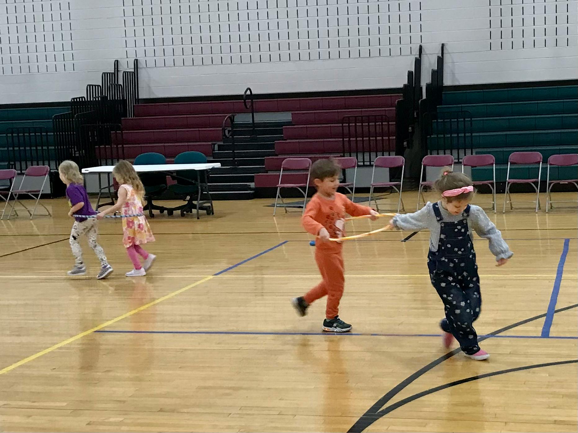 Children playing with hoops on a gymnasium floor