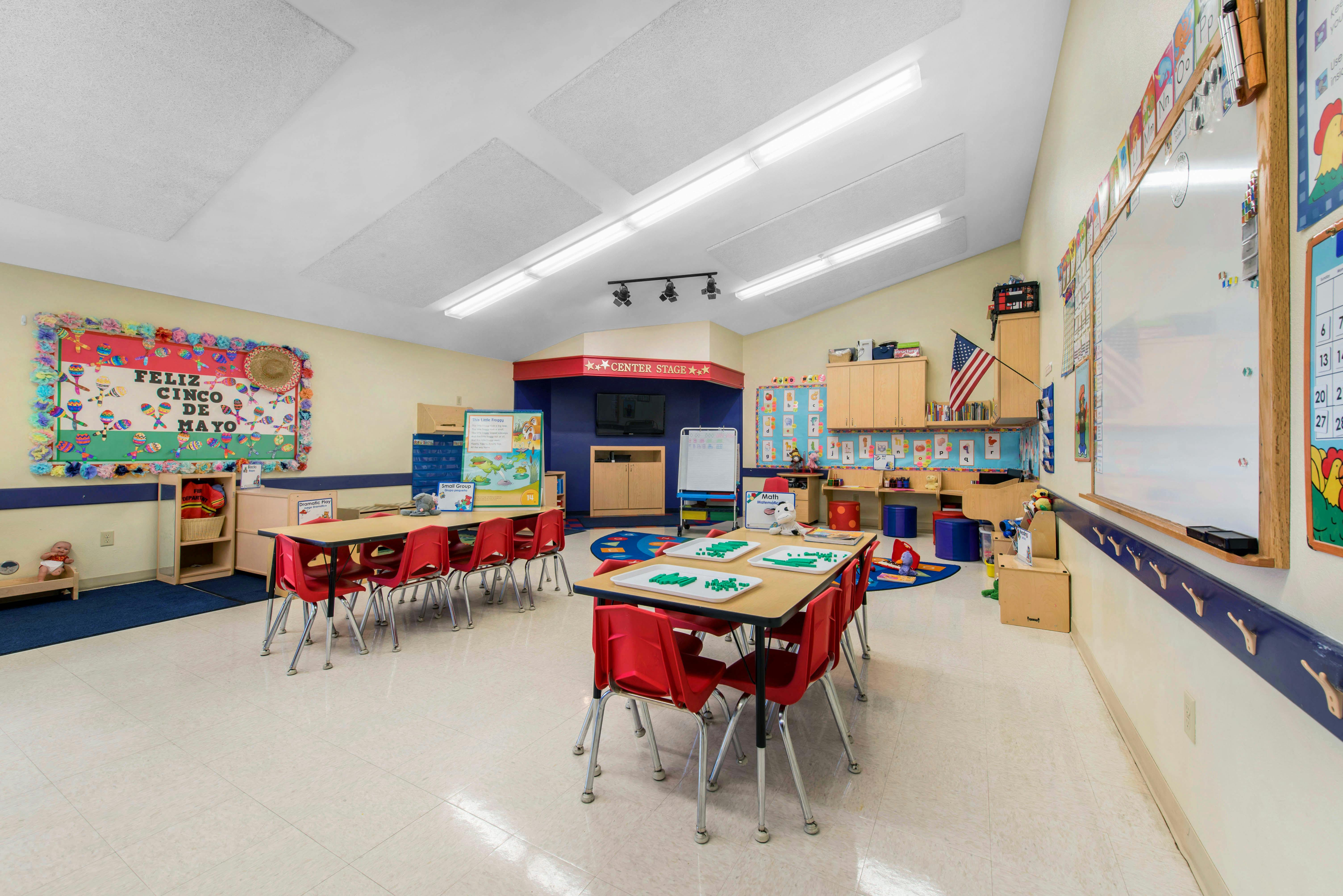 Classroom with tables, red chairs, and a Cinco de Mayo bulletin board