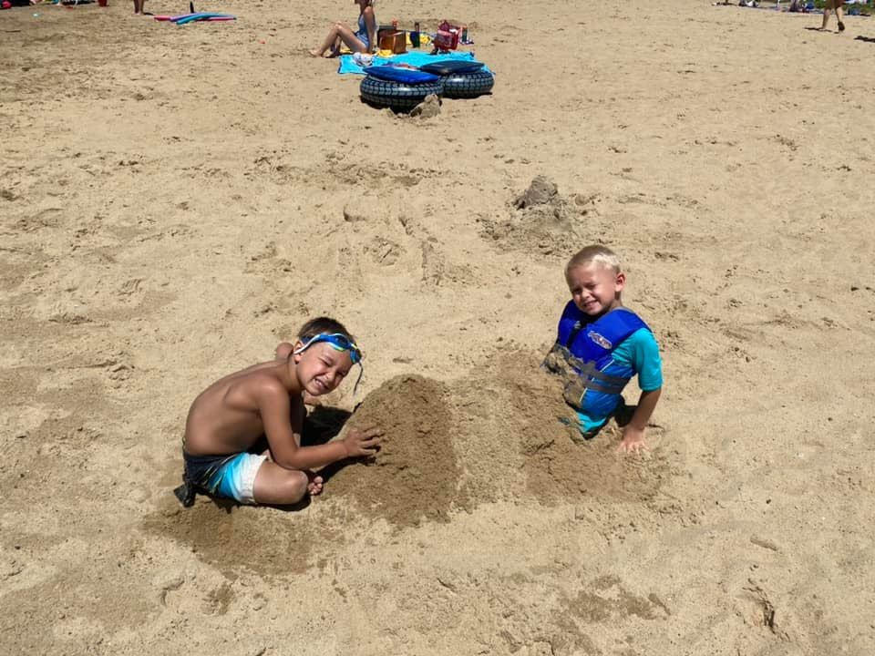Two children playing in sand on a beach