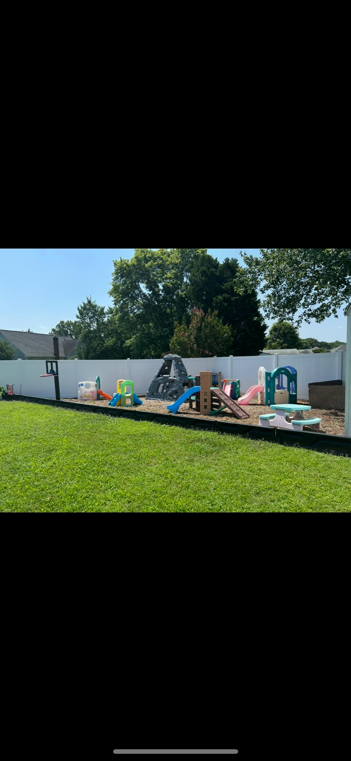 Outdoor play area with various slides, climbers, and a small picnic table