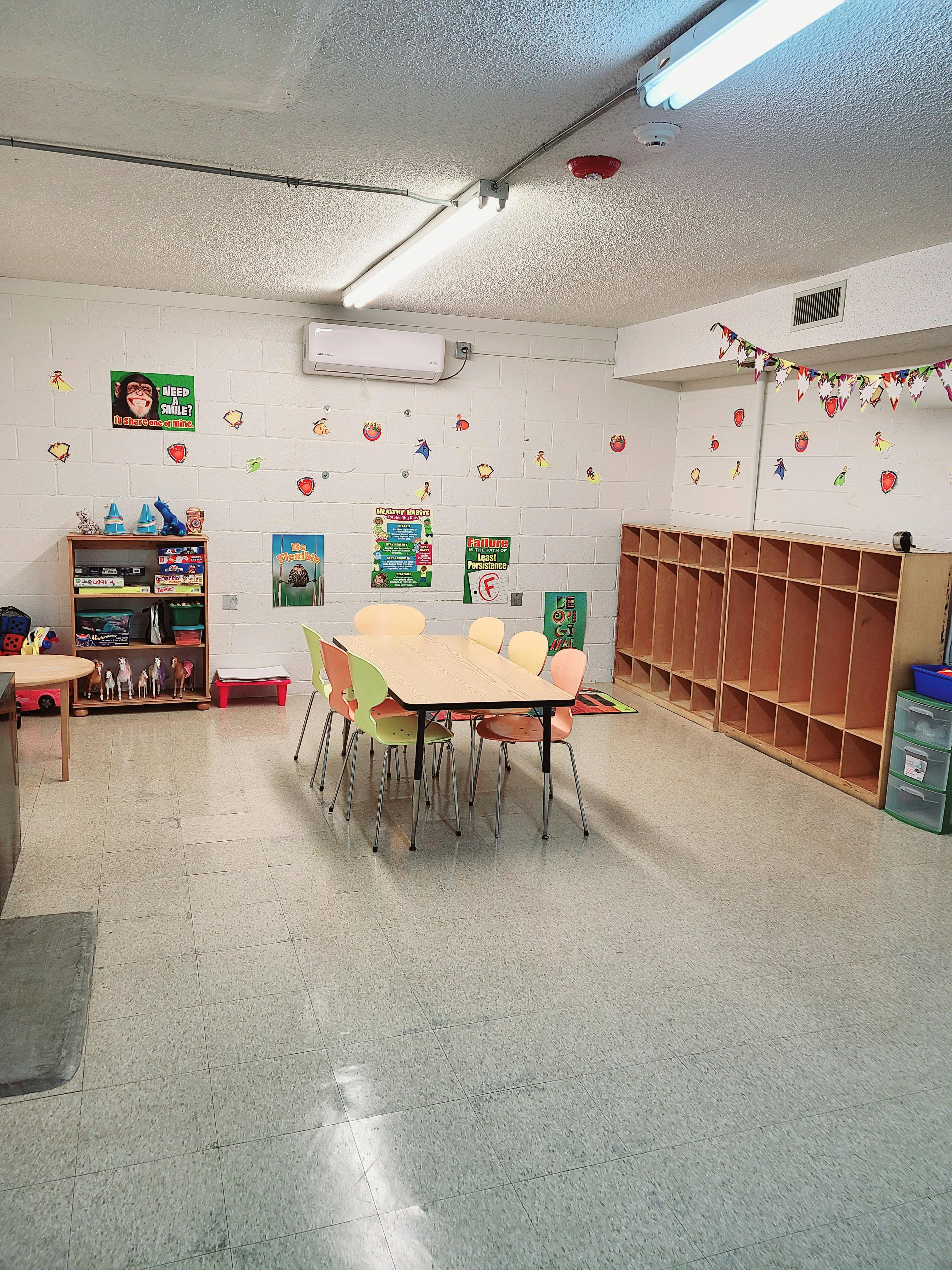 Classroom with small tables and chairs, storage cubbies, and wall decorations