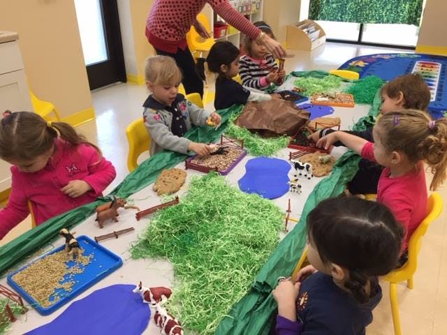 Children playing with sensory materials at a table