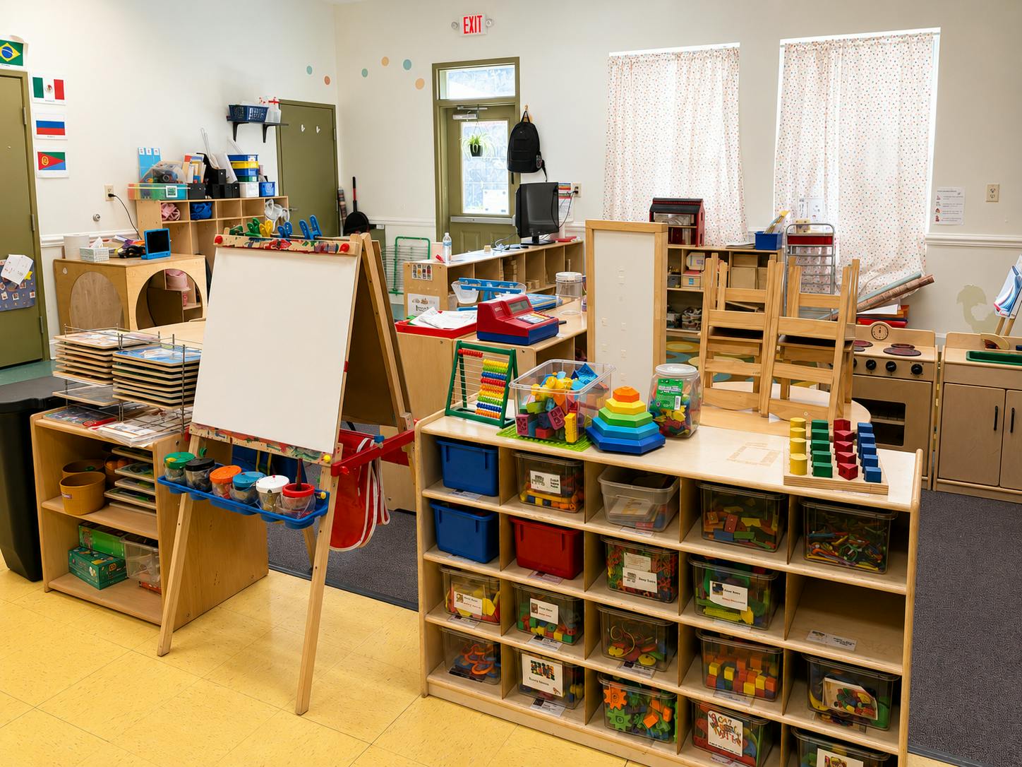 Classroom filled with wooden storage shelves full of learning toys and an easel