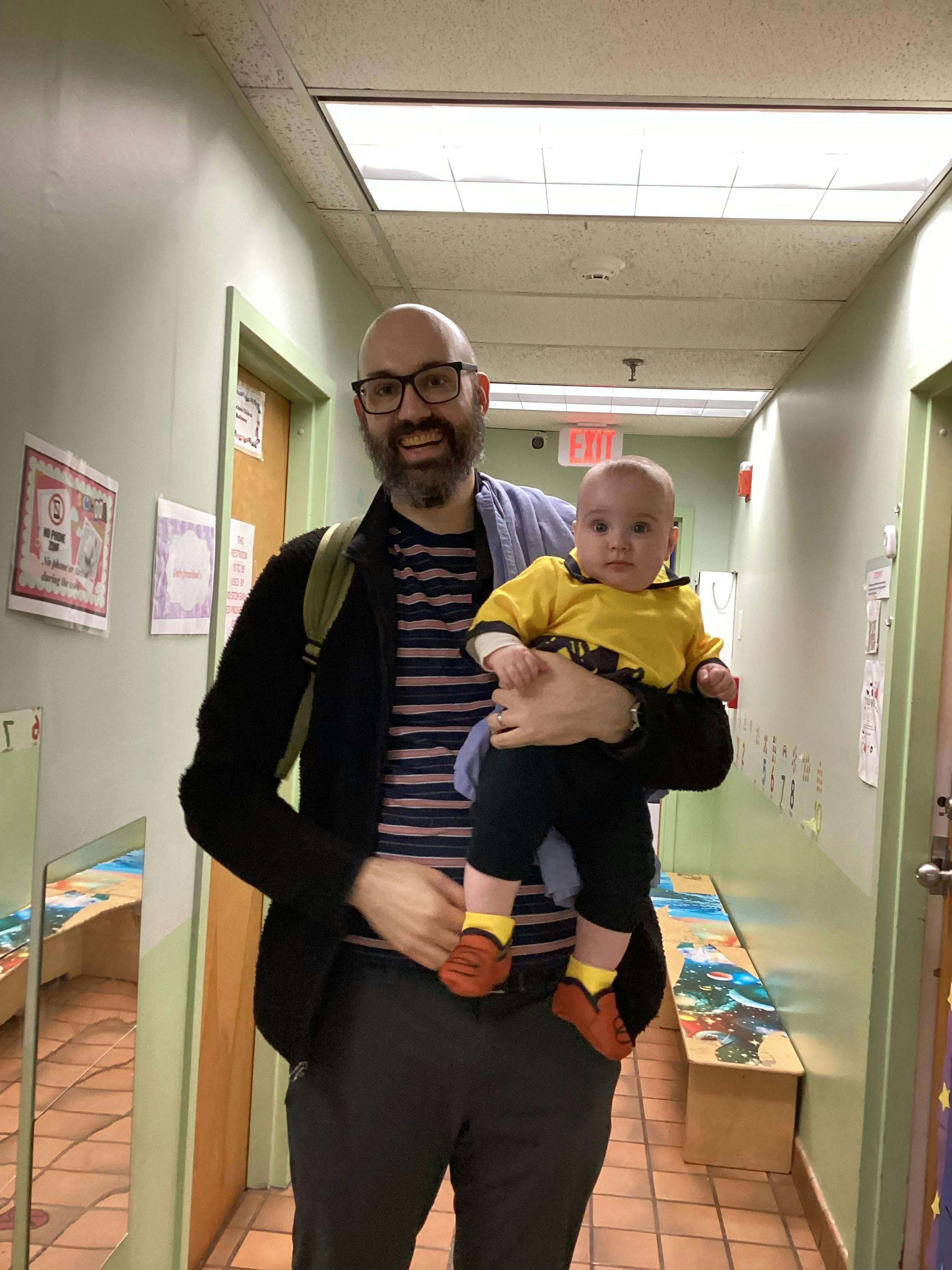 Person holding a child in a hallway