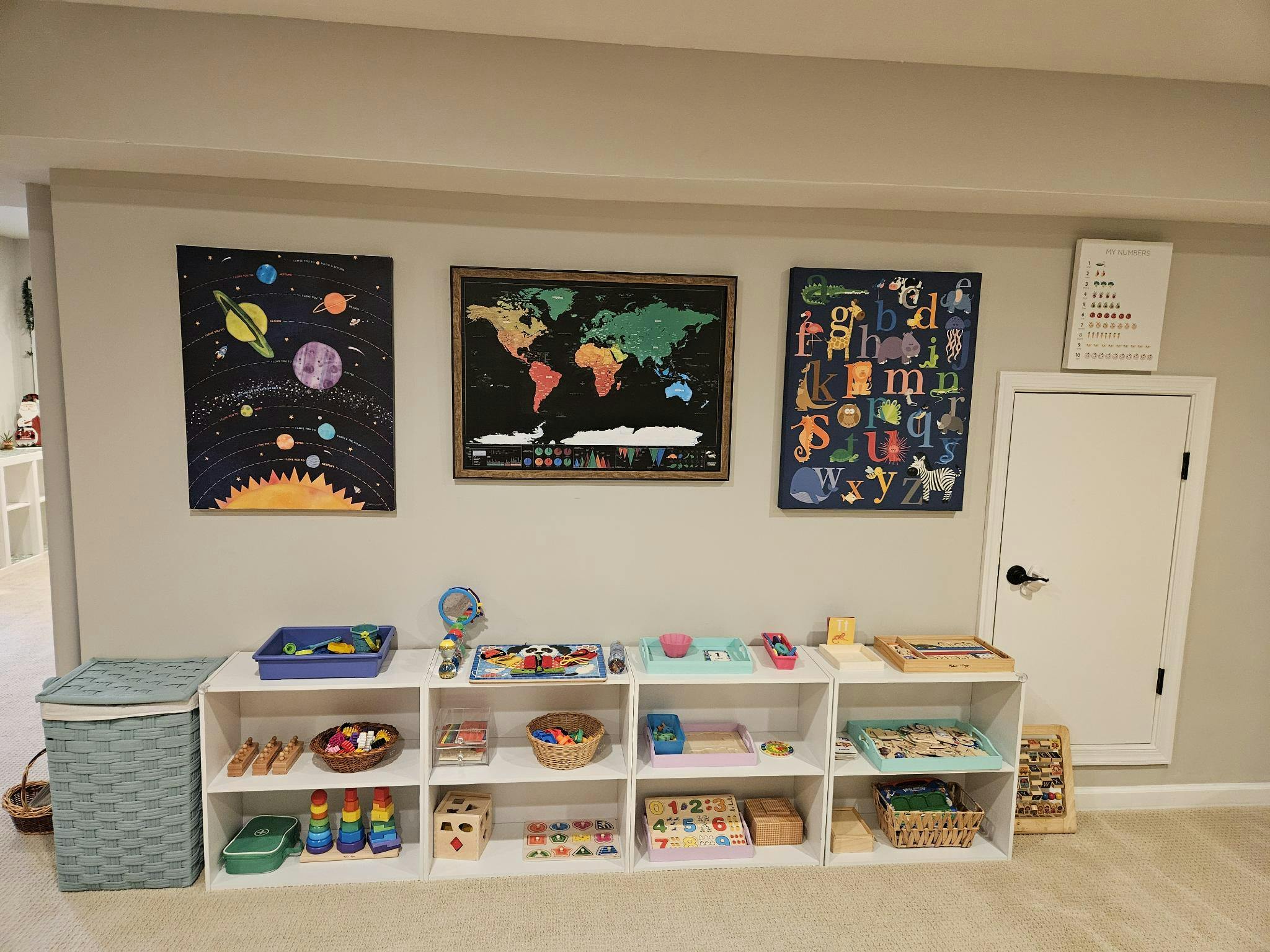 Children's play area with shelves of toys and educational charts on the wall