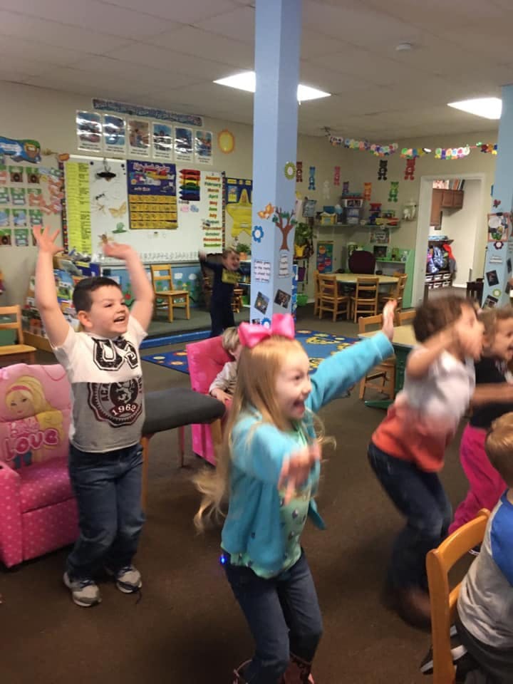 Children jumping and dancing in a classroom