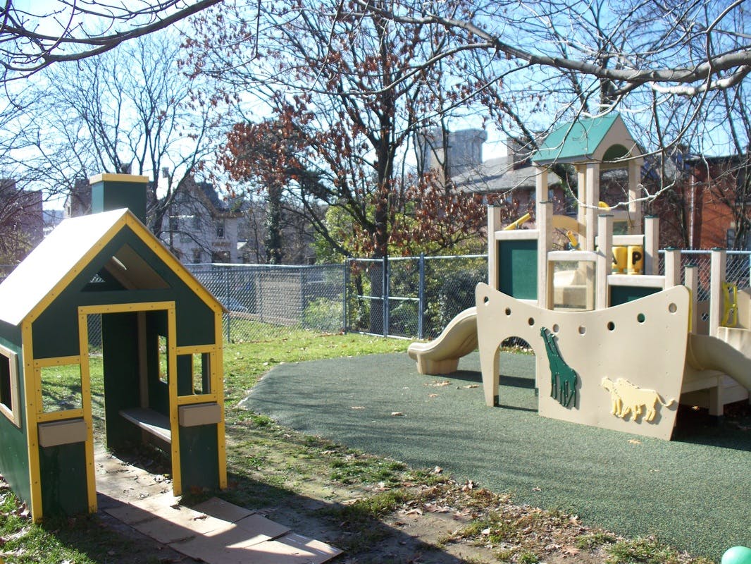 Playground with a small playhouse and a larger play structure with a slide
