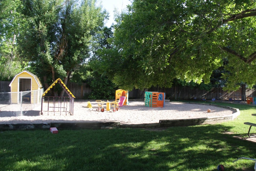 Playground with sand, small playhouses, and colorful play equipment