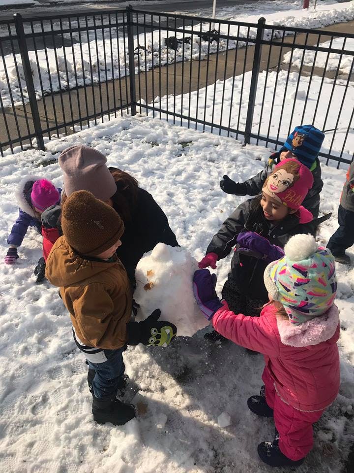 Children building a snowman in the snow