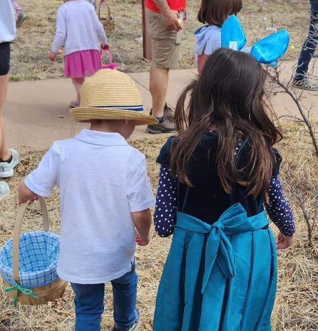 Two children walking, one holding a basket