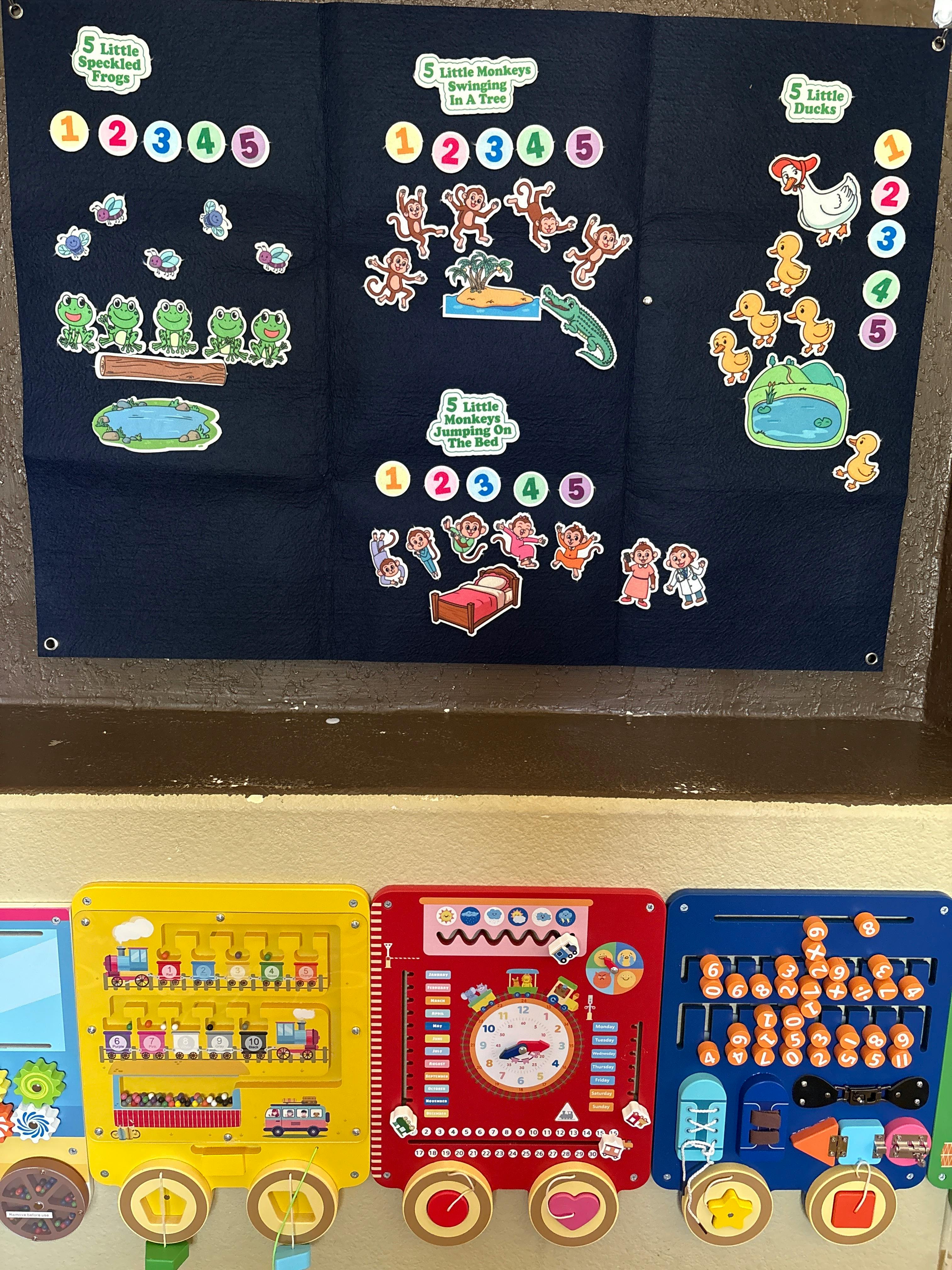 Felt board with nursery rhyme cutouts and three activity boards mounted on a wall