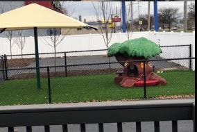 Playground with a yellow umbrella and a tree-shaped play structure