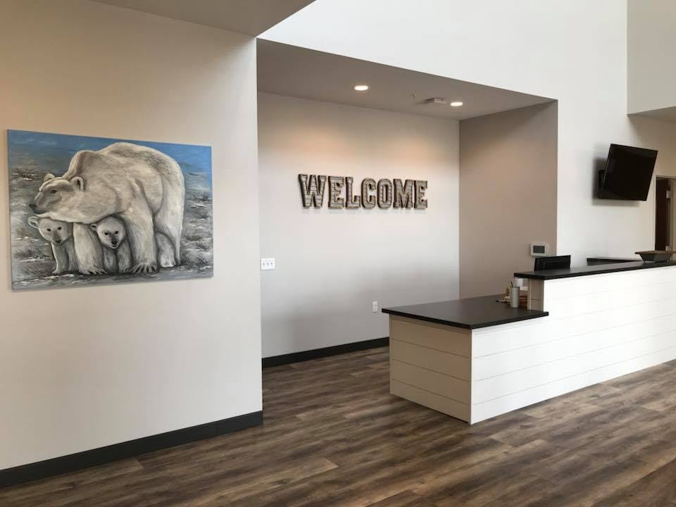 Reception area with a "WELCOME" sign and a painting of polar bears