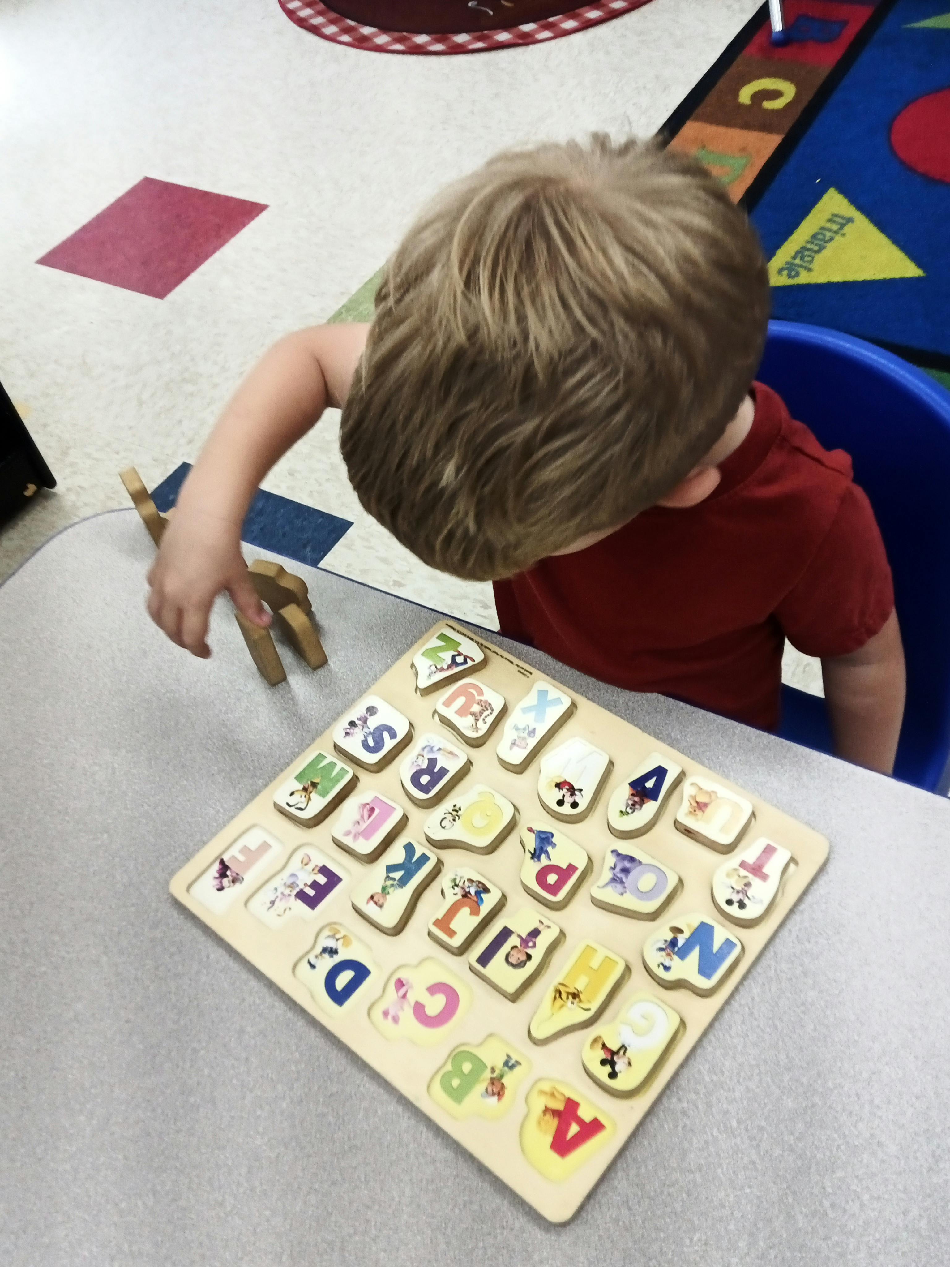 Child playing with an alphabet puzzle