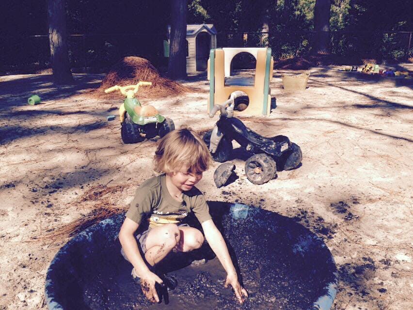 Child playing in a mud puddle