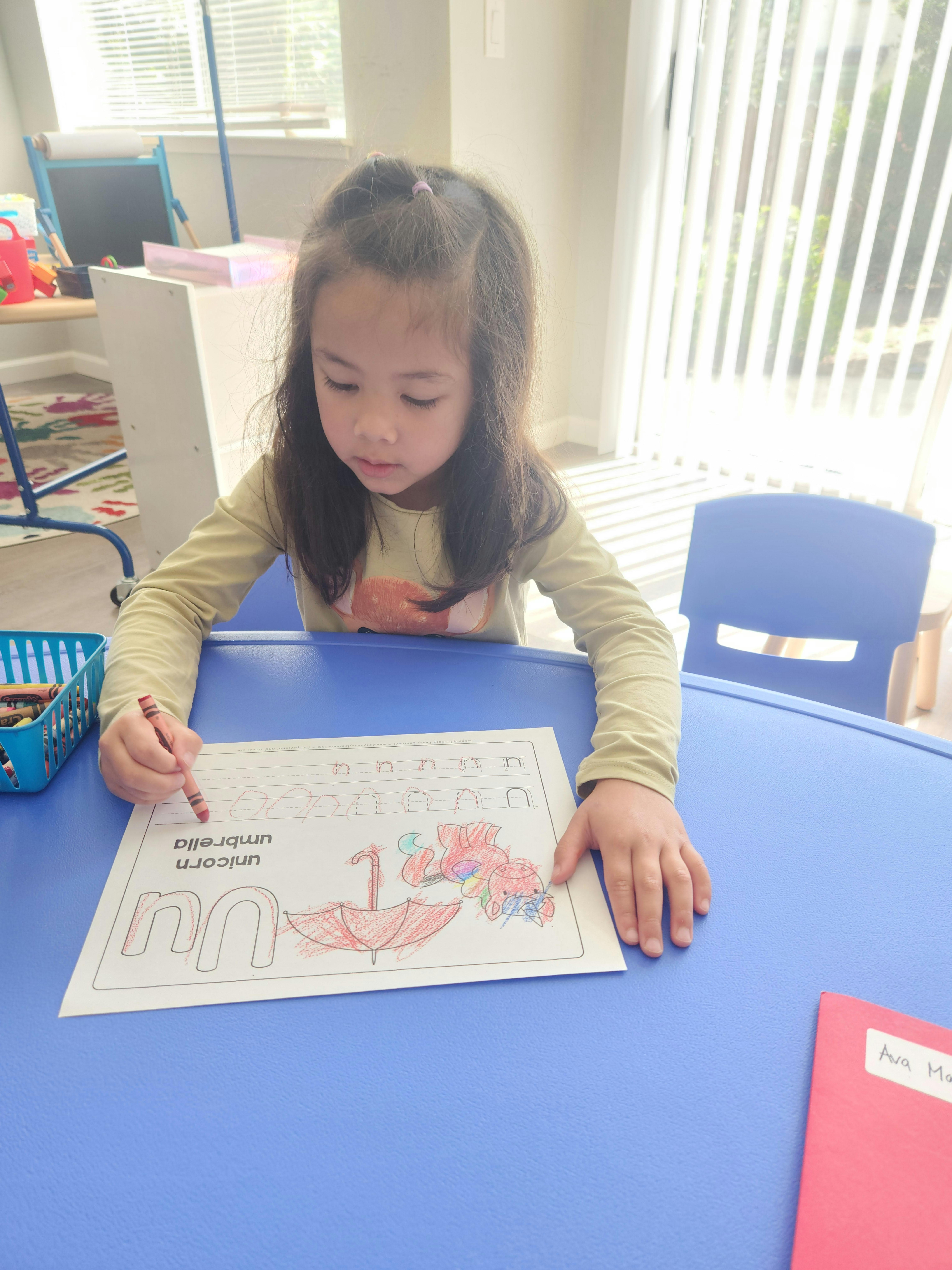 Child coloring a worksheet at a table