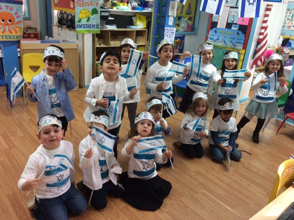 Group of children holding small flags in a classroom