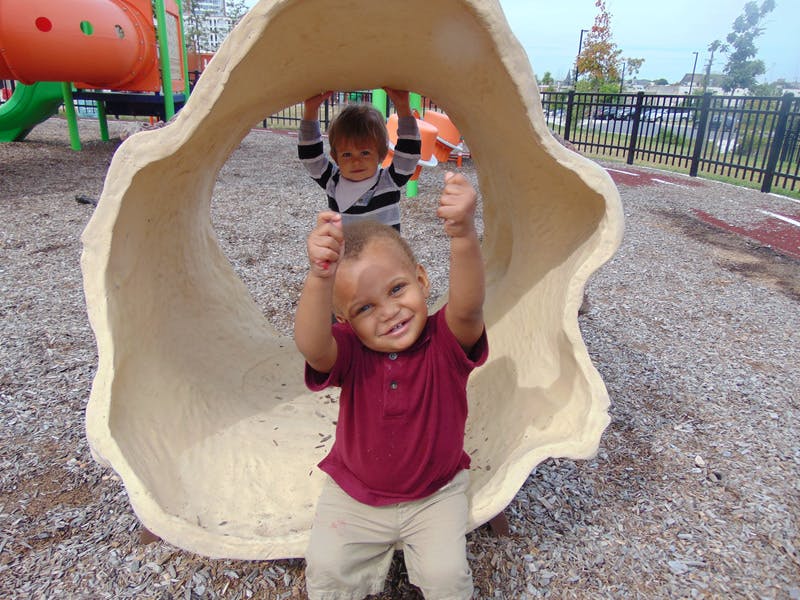 Two children playing in a tunnel on a playground