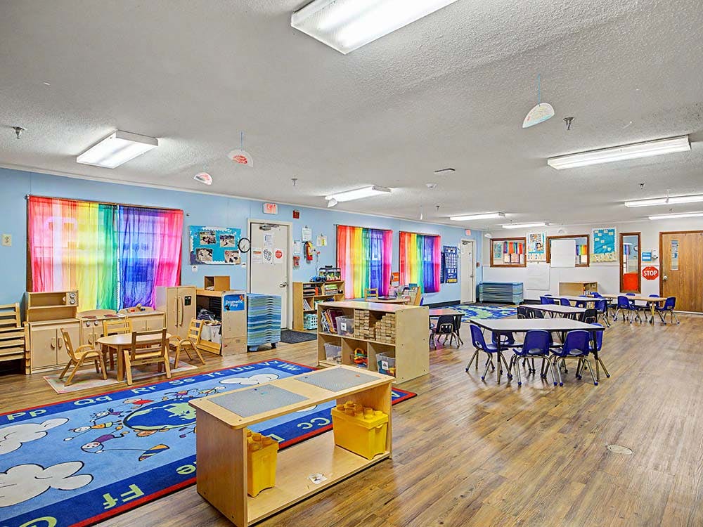 Empty colorful children's classroom with small tables and chairs