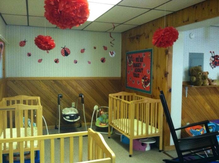 Nursery room with multiple cribs and baby swings