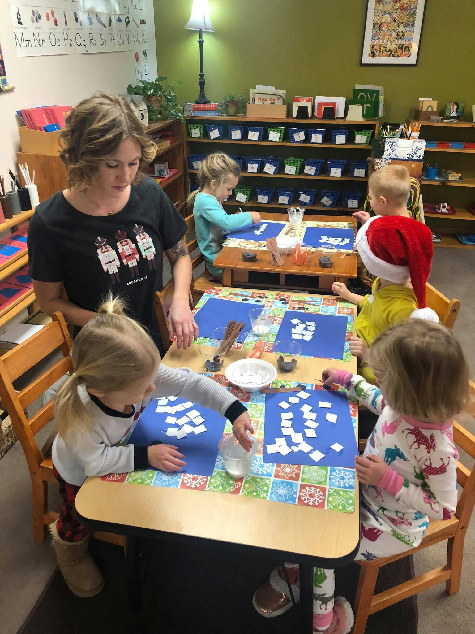 Adult and children doing crafts at a table in a classroom