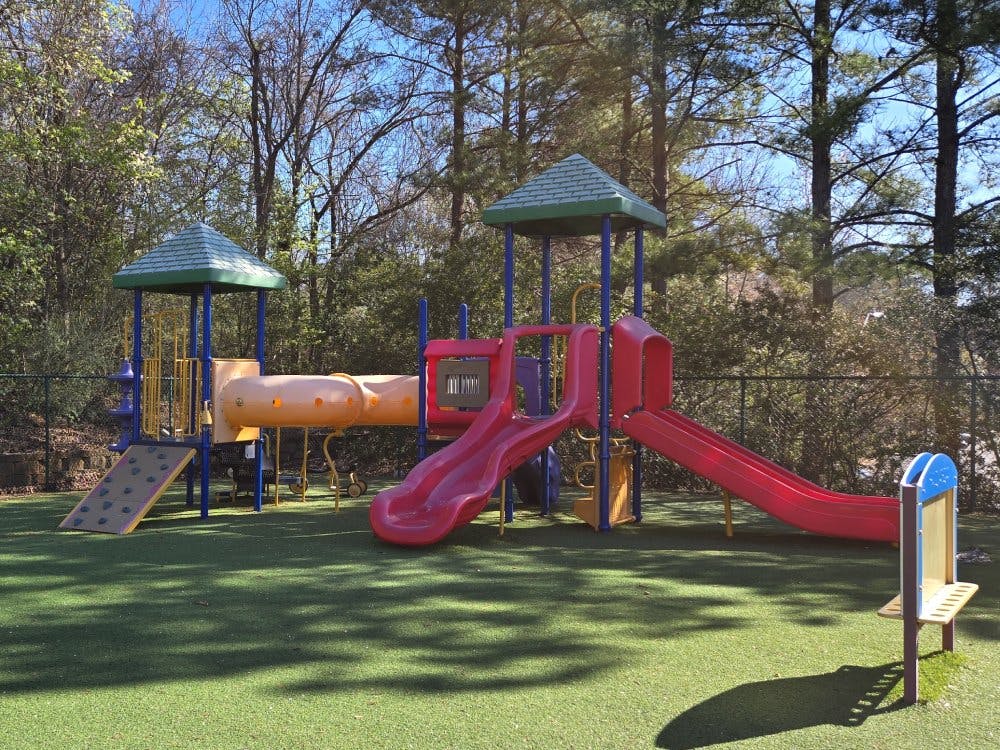 Colorful playground with multiple slides and climbing structures on green turf
