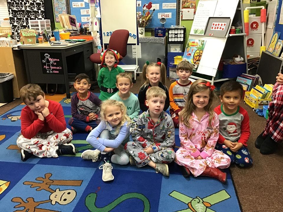 Group of children sitting on a rug in a classroom