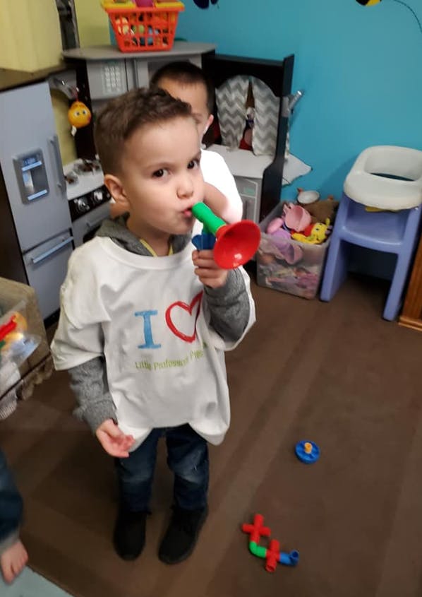 Child playing with a toy horn