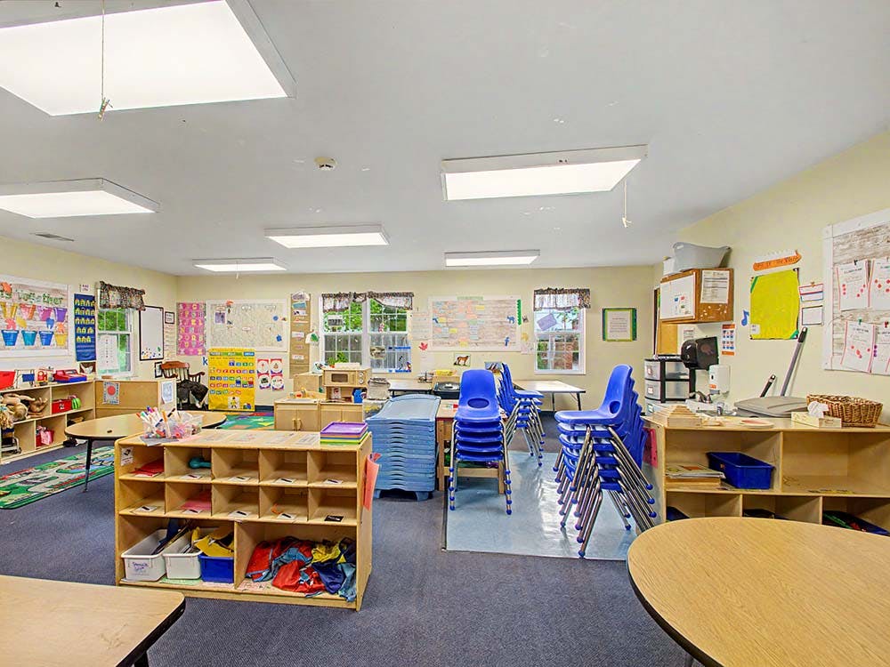 Empty colorful children's classroom with blue chairs stacked