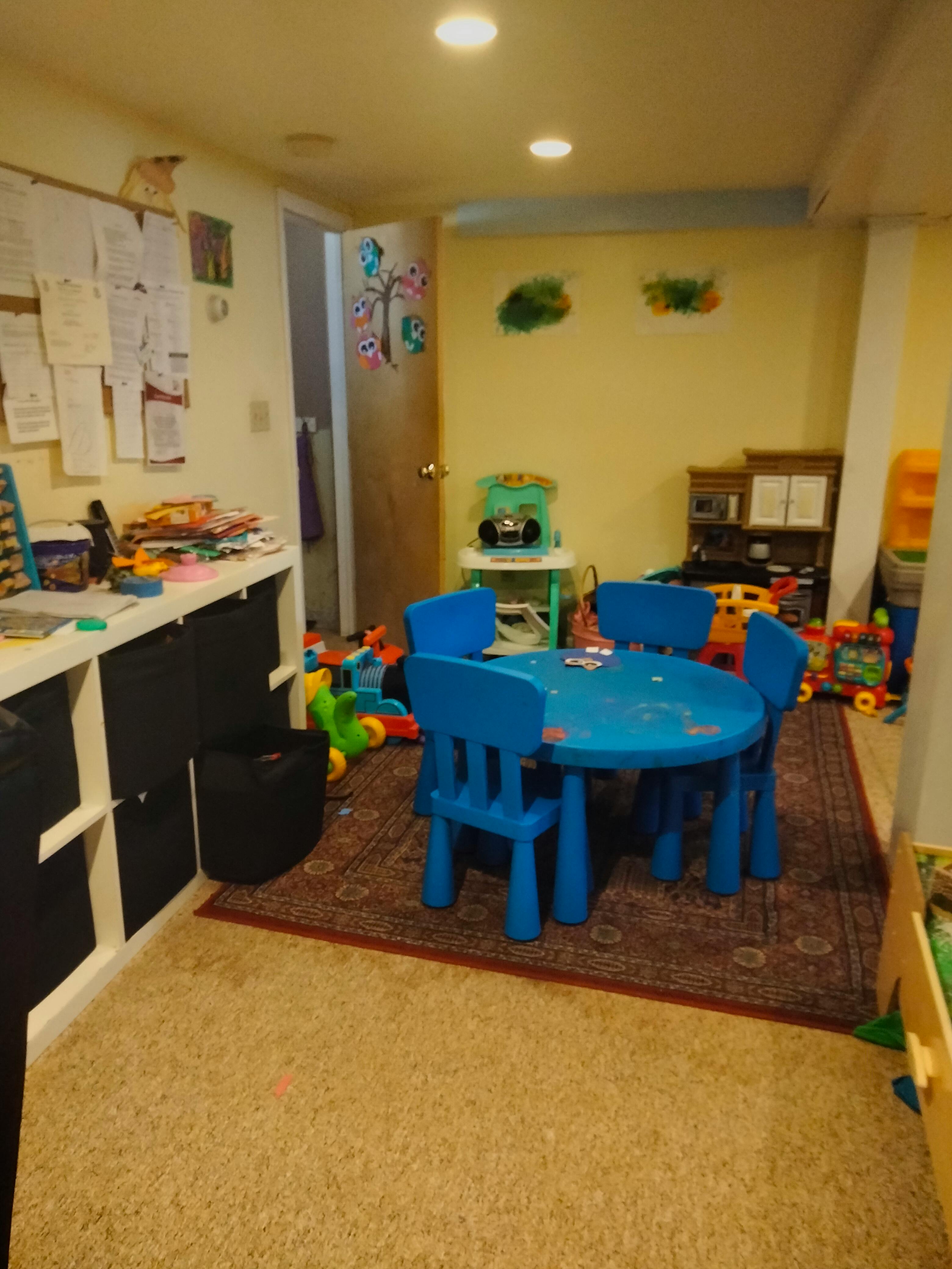 Playroom with blue table and chairs, toys on the floor
