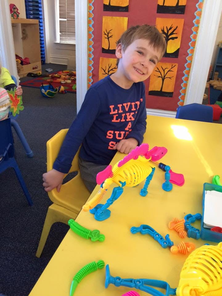 Child sitting at a table with colorful toys