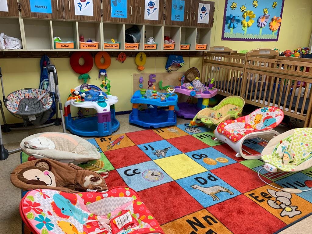 Infant room with cribs, play mats, and baby bouncers