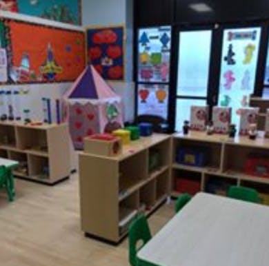 Playroom with a small tent, shelves, and tables