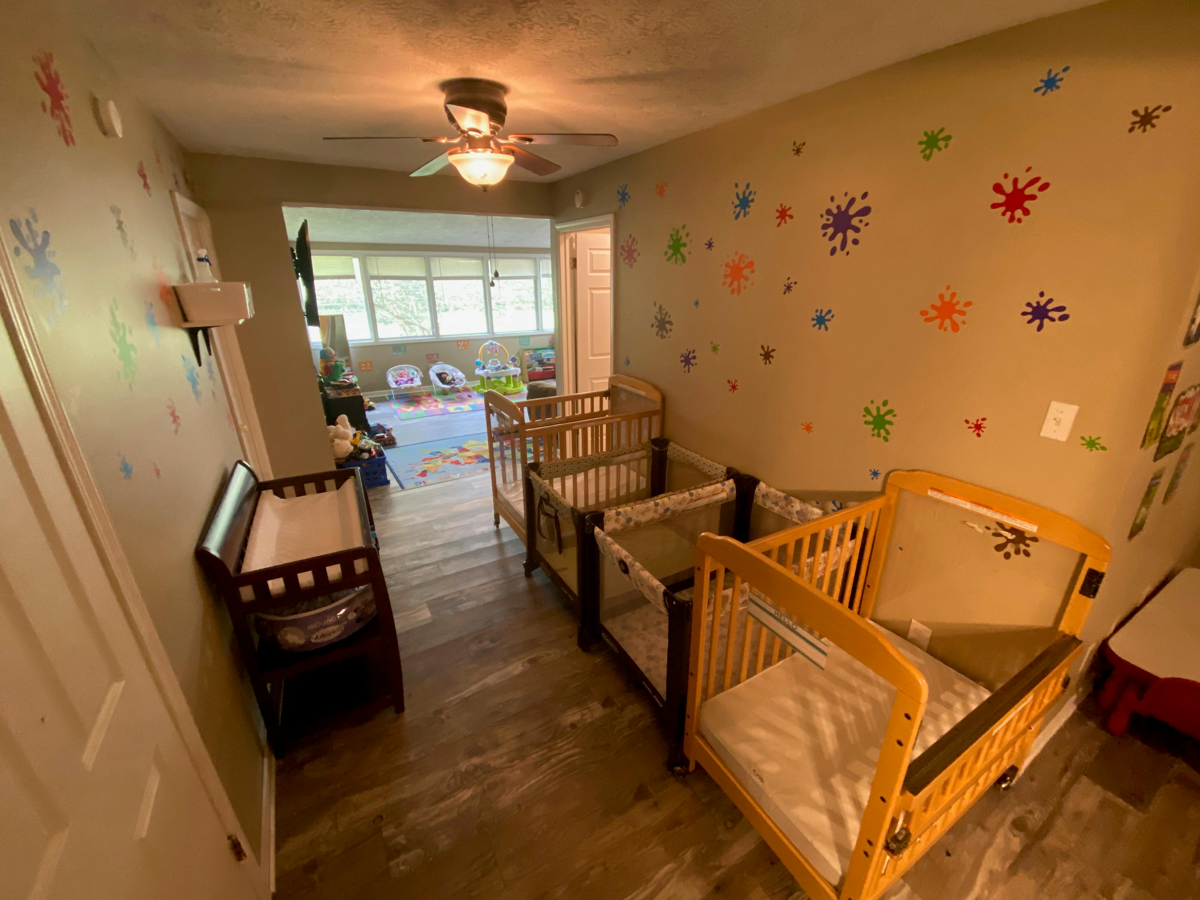 Room with multiple cribs and a changing table